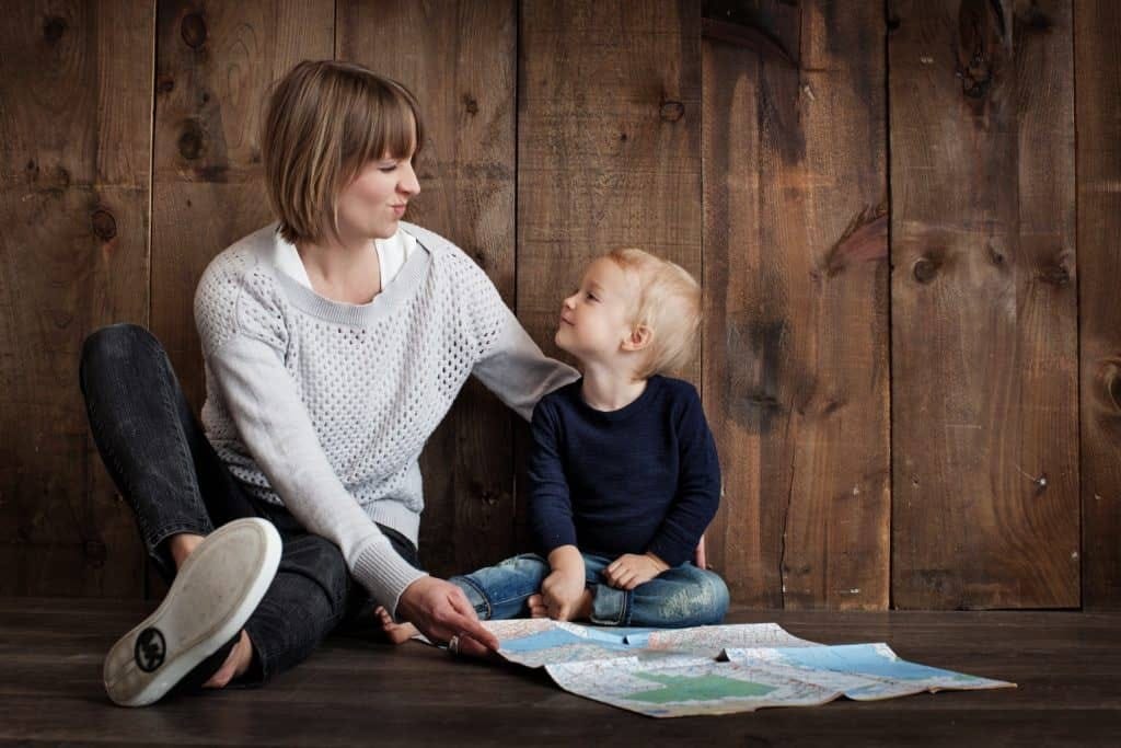 A mother and child utilizing tenant services in Oakland, sitting on the floor and looking at a map.